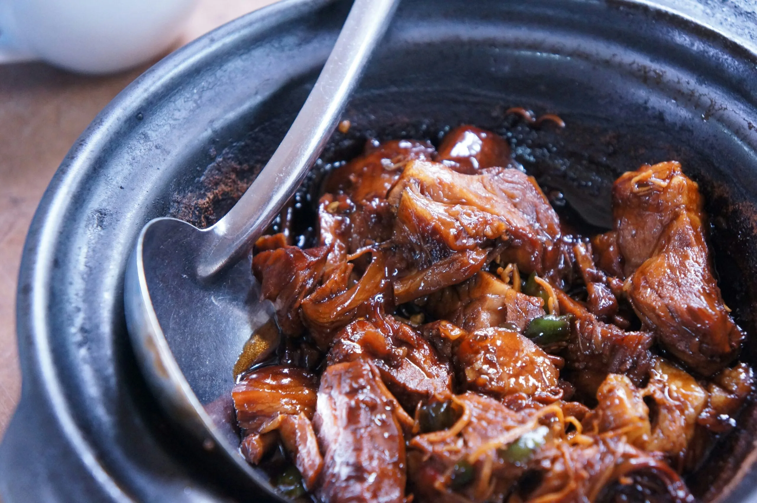 meat with sauce in black bowl Flavors of Goa